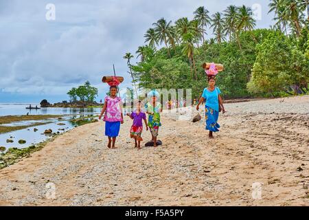 Frau zu Fuß entlang Strand Durchgangsstraße Last auf dem Kopf trägt Stockfoto