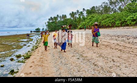 Frau zu Fuß entlang Strand Durchgangsstraße Last auf dem Kopf trägt Stockfoto