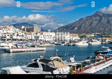 PUERTO BANUS ANDALUSIEN SPANIEN HAFEN UND BOOTE MIT BERGEN UND WOLKEN Stockfoto