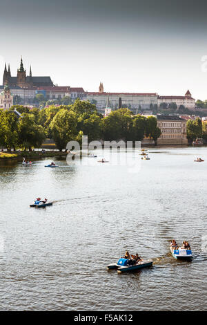 Menschen in Paddelboote in Moldau, Pragerburg und Strelecky Insel im Hintergrund, Prag, Tschechische Republik Stockfoto