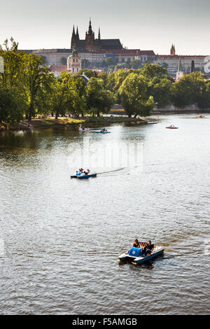 Menschen in Paddelboote in Moldau, Pragerburg und Strelecky Insel im Hintergrund, Prag, Tschechische Republik Stockfoto