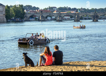 Menschen genießen einen Sommertag am Strand, Strelecky Ostrov, Altstadt im Hintergrund, Prag, Tschechische Republik Stockfoto