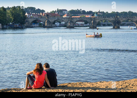Menschen genießen einen Sommertag am Strand, Strelecky Ostrov, Altstadt im Hintergrund, Prag, Tschechische Republik Stockfoto