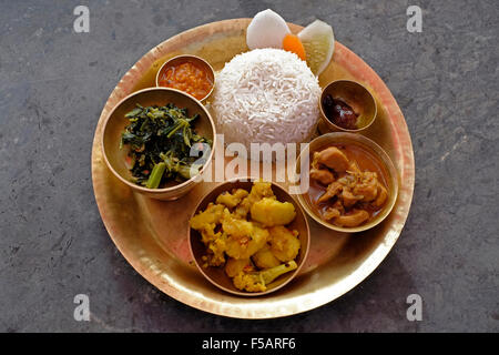 Eine Runde Platte mit Dal Bhat Tarkari bestehend aus einer Auswahl verschiedener Gerichte, darunter Reis, Gemüse Curry, Chutney und Gurke. Nepal Stockfoto