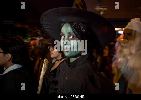 New York, NY - 31. Oktober 2015. Eine Frau mit grünen Gesicht Make-up und ein Hexenhut auszusehen wie Elphaba, die böse Hexe in The Wiz in Greenwich Village Halloween Parade gebildet. Stockfoto