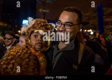 New York, NY - 31. Oktober 2015. Ein Vater trägt sein Kind, die als ein Pelztier gekleidet ist, in Greenwich Village Halloween Parade. Da Halloween auf einen Samstag fiel, gab es mehr Kinder als üblich in die Parade. Stockfoto