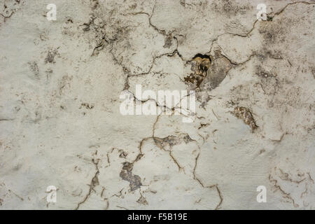 Verrückt und gebrochene bemalte Rendern auf eine Mauer aus Stein. Verwitterte Farbe Textur, alte Farbe Textur, raue Textur, Farbe Rissbildung. Stockfoto