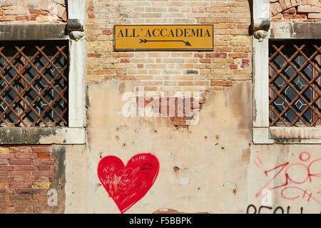 Abonnieren der Accademia-Brücke an zerbröckelnden Wand mit Graffiti rote Herzen rosten Metallgitter Venedig Veneto Italien Europa Stockfoto