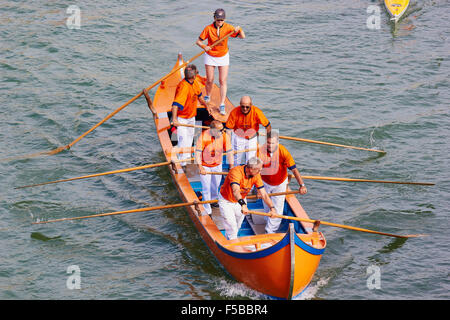 Ein Boot, die Teilnahme an der Vogalonga mit Team tragen helle orange Reihen entlang des Canal Grande Venedig Veneto Italien Europa Stockfoto