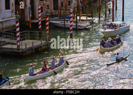 Boote, die Teilnahme an der Vogalonga Zeile entlang dem Canale Grande vorbei gestreiften Liegeplatz Pole und ein Wasser taxi Venedig Veneto Italien Stockfoto