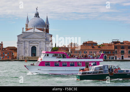 Boot voller Touristen in den Canale della Giudecca mit Kirche Chiesa Del Santissimo Redentore auf der Giudecca Insel Venedig Veneto Italien Stockfoto