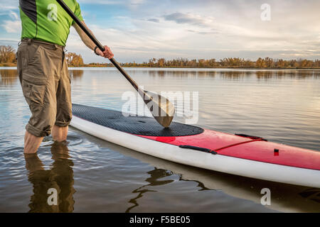 männlichen Paddler beginnt paddeln Training auf seinem Stand up Paddleboard auf einem See in Colorado Stockfoto