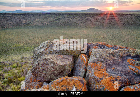 Sonnenaufgang über den Resten eines vulkanischen Kegels in den Krater des Moon National Monument in der Snake River Plain in der Nähe von Arco, Idaho. Stockfoto