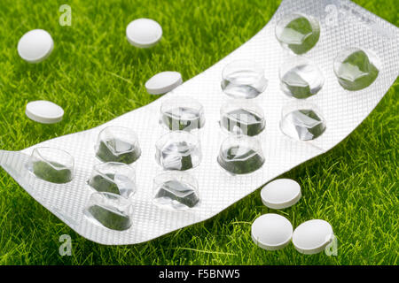 Weißen Pillen und leere Pille Blisterpackung auf dem Rasen Stockfoto