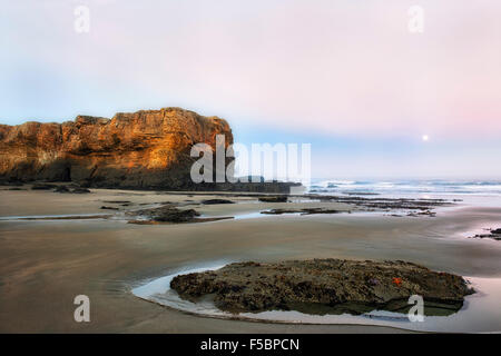 Ersten Ampel zeigt die Sandstein Landzunge an Teufels Punchbowl State Natural Area mit der Einstellung Mond an Oregons Küste. Stockfoto