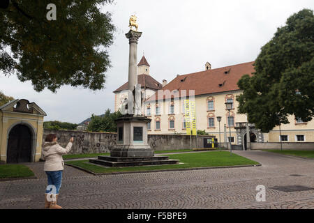 Eine Frau hält inne, um ein Bild neben der Hofburg aufzunehmen und die Statue des Bischofs Zacharias errichtet 1909 Brixner Gedenken Stockfoto