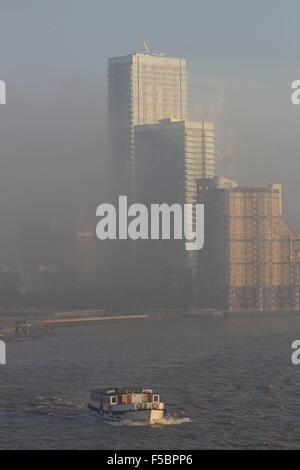 London, UK.  1. November 2015. Ein Dichter Nebel rollt wieder aus dem Osten zur Deckung der Docklands und seine Wahrzeichen Wolkenkratzer zu verstecken. Nebel weiter Osten über Rotherhithe, so dass für eine Eeir Sonnenuntergang über den Fluss Themse. 1. November 2015. Bildnachweis: Glenn Sontag / Alamy Live News Stockfoto