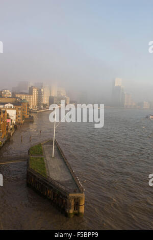 London, UK.  1. November 2015. Ein Dichter Nebel rollt wieder aus dem Osten zur Deckung der Docklands und seine Wahrzeichen Wolkenkratzer zu verstecken. Nebel weiter Osten über Rotherhithe, so dass für eine Eeir Sonnenuntergang über den Fluss Themse. 1. November 2015. Bildnachweis: Glenn Sontag / Alamy Live News Stockfoto