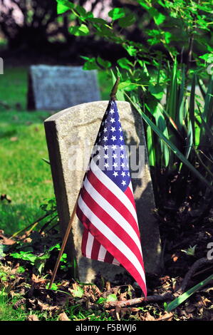 Ein Grab Marker, vor langer Zeit von der Zahn der Zeit unlesbar gemacht, ist mit einem amerikanischen Flagge für den vierten Juli geschmückt. South Elgin, Illinois, USA. Stockfoto