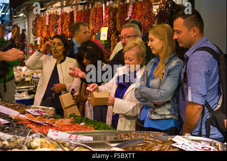 Touristen, die Austern auf Schalentiere Stall in La Boqueria Markt Las Ramblas Barcelona Katalonien Spanien ES Essen Stockfoto