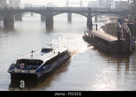 MBNA Thames Clippers (ehemaliger Sponsor von Thames Clippers) verlässt den Bankside Pier mit Southwark und Tower Bridge im Hintergrund. Am frühen Morgen Stockfoto