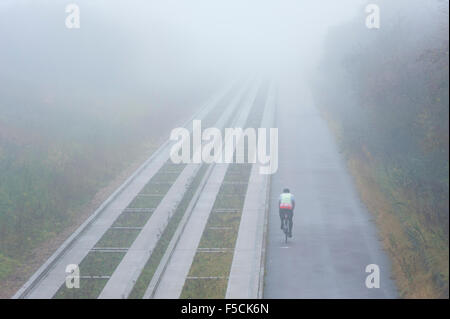 Cambridgeshire, Großbritannien. 2. November 2015. Ein einsamer Radfahrer Köpfe in Richtung Cambridge unterwegs im dichten Nebel im Laufe des Vormittags geführte Bus pendeln. Die milden Anfang bis November dürfte weiterhin mit mehr Herbst Nebel am Morgen Morgen. Bildnachweis: Julian Eales/Alamy Live-Nachrichten Stockfoto