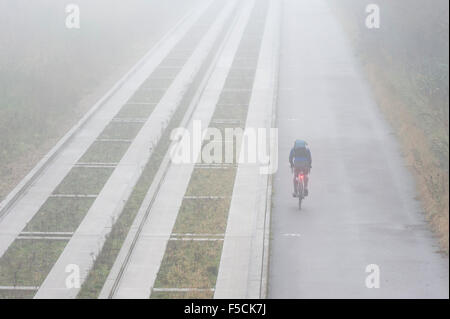 Cambridgeshire, Großbritannien. 2. November 2015. Ein einsamer Radfahrer Köpfe in Richtung Cambridge unterwegs im dichten Nebel im Laufe des Vormittags geführte Bus pendeln. Die milden Anfang bis November dürfte weiterhin mit mehr Herbst Nebel am Morgen Morgen. Bildnachweis: Julian Eales/Alamy Live-Nachrichten Stockfoto