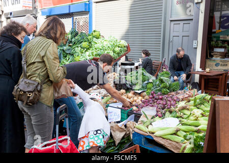 Menschen, die Einkaufen bei einem Landwirt Gemüse Marktstand (Islington Farmer Market, London, UK) Stockfoto