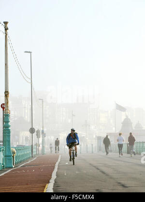 Brighton, Sussex UK Montag, 2. November 2015 - Radfahrer und Läufer haben keine Probleme mit den nebligen Reisebedingungen an Brighton Strandpromenade heute Morgen Nebel schwere Reise Störungen in ganz Großbritannien heute Morgen vor allem an den großen Flughäfen und auf den wichtigsten Straßen Credit verursacht: Simon Dack/Alamy Live News Stockfoto