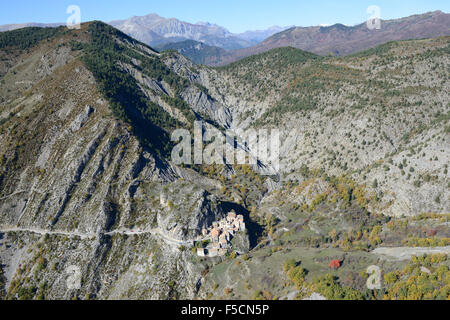 LUFTAUFNAHME. Kleines Dorf, das neugierig auf einem Felsvorsprung in einem abgelegenen Gebiet thront. Auvare, Alpes-Maritimes, Hinterland der französischen Riviera, Frankreich. Stockfoto