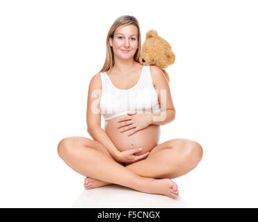 Porträt einer glücklich schwanger Frau sitzt auf dem Boden und halten Bauch Stockfoto