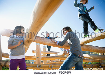 Familie auf Protokollen an sonnigen Spielplatz spielen