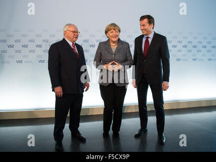 Berlin, Deutschland. 2. November 2015. Hubert Burda (L), Herausgeber und Präsident der Vereinigung von deutscher Zeitschrift Verleger (VDZ) und Stephan Scherzer (R), Geschäftsführer der VDZ, grüßen die deutsche Bundeskanzlerin Angela Merkel am "Publishers Gipfel 2015" - der deutsche Zeitschriftenverlage Konferenz - in Berlin, Deutschland, 2. November 2015. Der Verband der deutscher Zeitschrift Verleger (VDZ) organisiert der jährliche Branchentreff der deutschen Zeitschriften. Foto: BERND VON JUTRCZENKA/Dpa/Alamy Live-Nachrichten Stockfoto