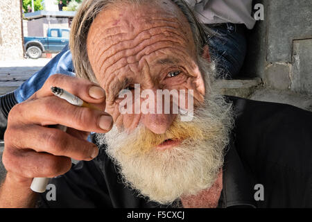 Ein Mann entspannt mit einer Zigarette in das Dorf Anogia auf Kreta in Griechenland Stockfoto