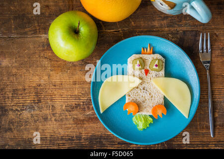 Gesunde Schule Frühstück für Kinder. Lustige Eule Sandwich und Obst auf Holztisch. Tabelle-Draufsicht Stockfoto