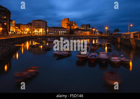 Ansicht von Castro Urdiales Stadtbild von Einbruch der Dunkelheit mit den Hafen und die Kirche Santa Maria De La Asuncion. Kantabrien, Spanien. Stockfoto