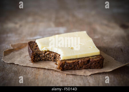 Brot und Käse auf rustikalen Tisch. Einfaches Essen Stockfoto