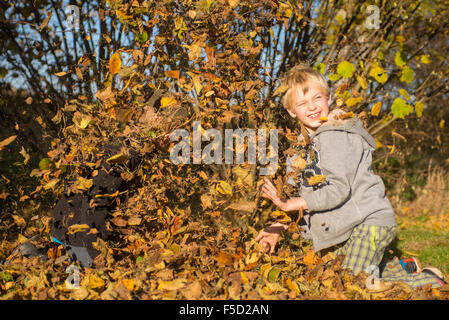 Zwei Kinder Jungs spielen, werfen Herbst fährt vom Stapel in den Garten, herbstliche Spaß, glücklich Stockfoto