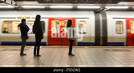 Passagiere warten auf einen Kreis oder Bezirk Linie u-Bahn auf die Londoner U-Bahn am Denkmal / Bank Station, London, UK Stockfoto