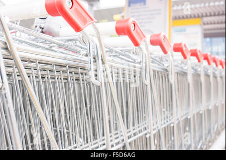 Zeilen der Einkaufswagen auf dem Parkplatz in der Nähe von Eingang des Supermarktes Stockfoto