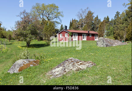 MALARDALEN, SCHWEDEN AM 13. MAI 2012. Blick auf ein Gartenhaus, Garten im Frühsommer. Falu rot lackiert Konstruktionen. Editorial. Stockfoto