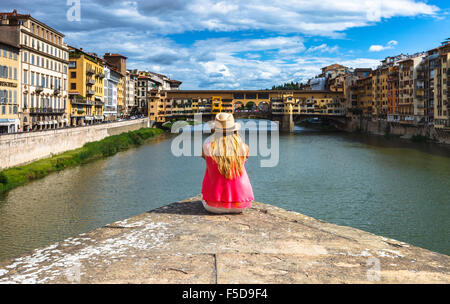 Eine junge Frau, genießen den Blick auf die Ponte Vecchio und den Fluss Arno, Florenz, Toskana, Italien. Stockfoto
