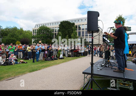 Menschen spielen Ukulelen an den grossen Busk, Teil der Ukulele Festival von Großbritannien in Cheltenham, Gloucestershire, Vereinigtes Königreich Stockfoto