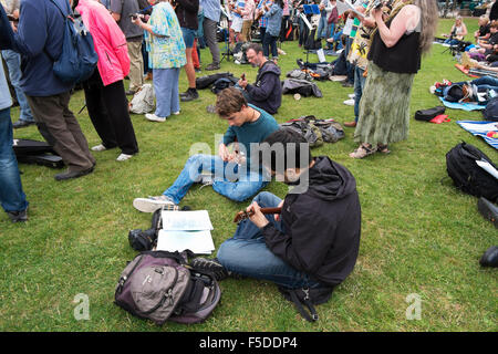 Menschen spielen Ukulelen an den grossen Busk, Teil der Ukulele Festival von Großbritannien in Cheltenham, Gloucestershire, Vereinigtes Königreich Stockfoto