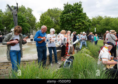 Menschen spielen Ukulelen an den grossen Busk, Teil der Ukulele Festival von Großbritannien in Cheltenham, Gloucestershire, Vereinigtes Königreich Stockfoto