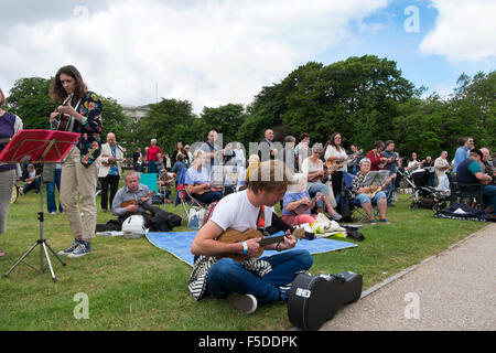 Menschen spielen Ukulelen an den grossen Busk, Teil der Ukulele Festival von Großbritannien in Cheltenham, Gloucestershire, Vereinigtes Königreich Stockfoto