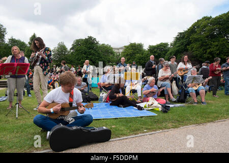 Menschen spielen Ukulelen an den grossen Busk, Teil der Ukulele Festival von Großbritannien in Cheltenham, Gloucestershire, Vereinigtes Königreich Stockfoto