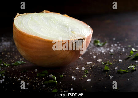 Reife Zwiebeln auf einem rustikalen Hintergrund mit Salz und Kräutern Stockfoto