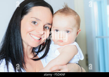 Fröhlicher 8 Monate altes Baby-junge mit Mutter Stockfoto