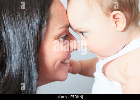 Fröhlicher 8 Monate altes Baby-junge mit Mutter Stockfoto